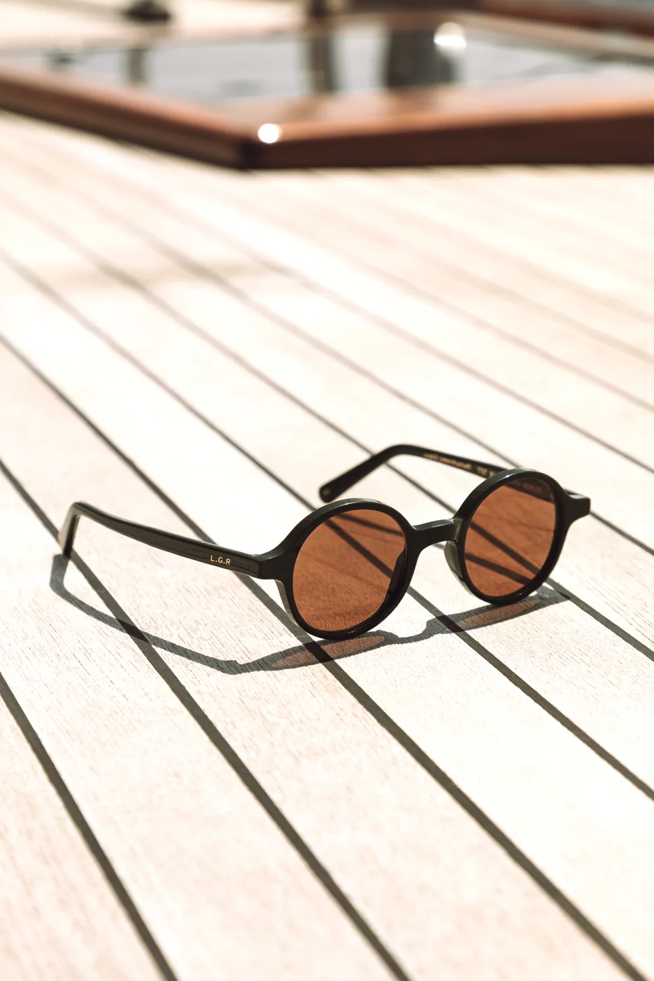 L.G.R classic round sunglasses on teak deck